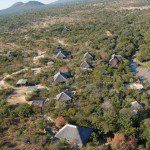 A scenic aerial shot of thatched chalets nestled in the natural landscape of Mountain View Lodge, Hoedspruit.