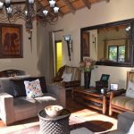 A cosy lounge at Moholoholo Forest Camp with earthy tones, safari-themed artwork, and a welcoming ambience.
