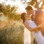 Bride and groom at sunset in tall grass, romantic moments at one of the top Drakensberg wedding venues in Hoedspruit.