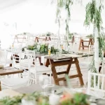 Rustic-chic wedding reception setup with greenery and wooden trestle tables at Moholoholo, one of the most charming Hoedspruit wedding venues.